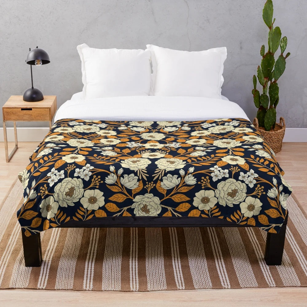 Navy blue, cream, and orange floral plush blanket with botanical garden inspired pattern