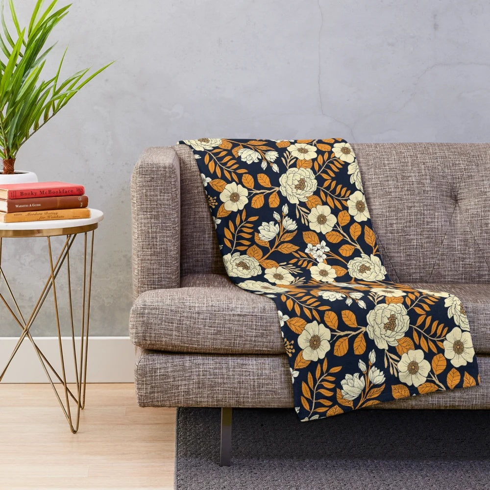 Navy blue, cream, and orange floral plush blanket with botanical garden inspired pattern