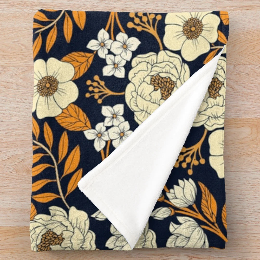 Navy blue, cream, and orange floral plush blanket with botanical garden inspired pattern