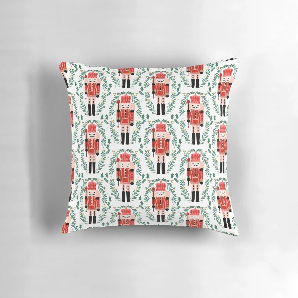 A vibrant red and green pillow featuring the iconic Nutcracker ballet design by artist Andrea Lauren.