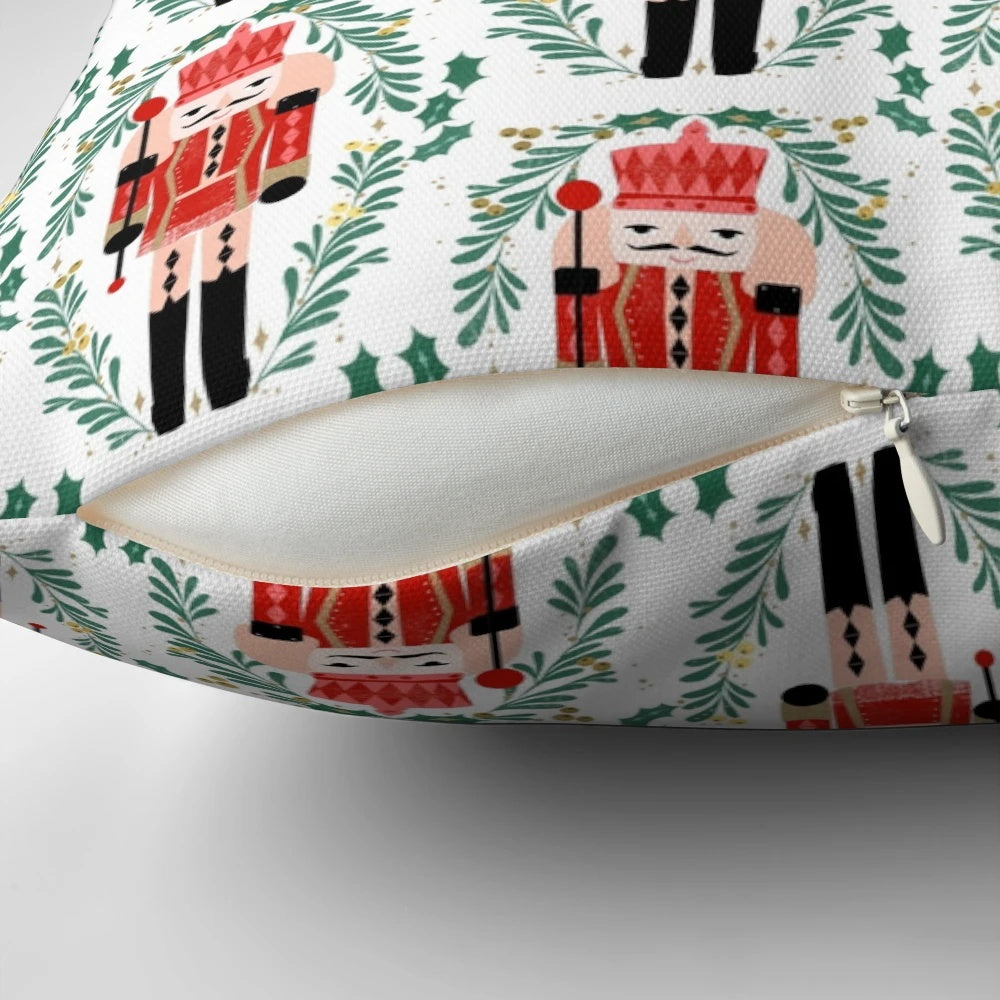 A vibrant red and green pillow featuring the iconic Nutcracker ballet design by artist Andrea Lauren.
