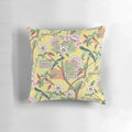 A beautiful decorative pillow featuring a chinoiserie-inspired design with vibrant parrots and peonies on a butter yellow background.