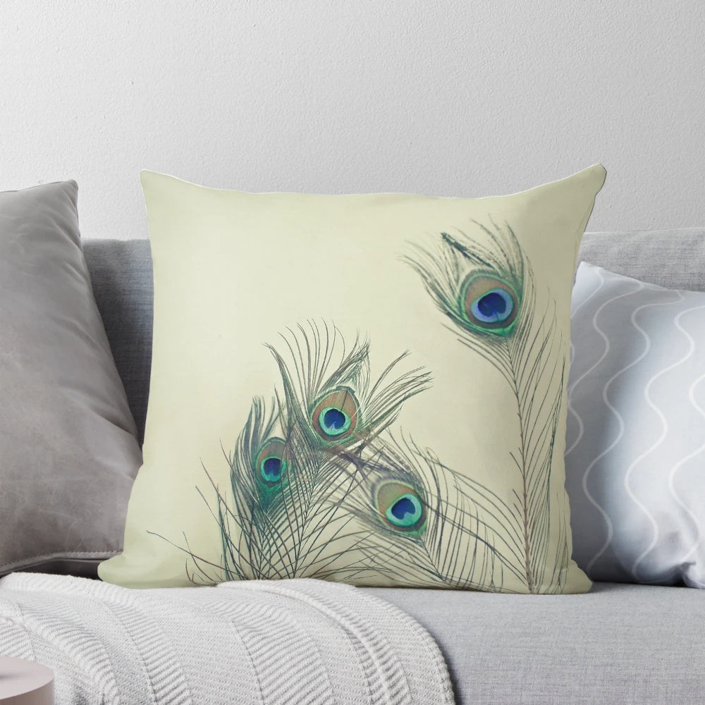 Decorative throw pillow featuring a stunning arrangement of peacock feathers in shades of turquoise, electric blue, emerald green, grey, gold, and bronze.