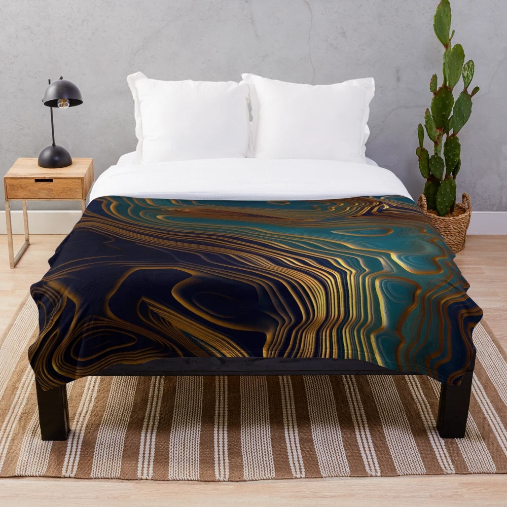 Peacock-inspired plush blanket with abstract ocean-like patterns and metallic accents