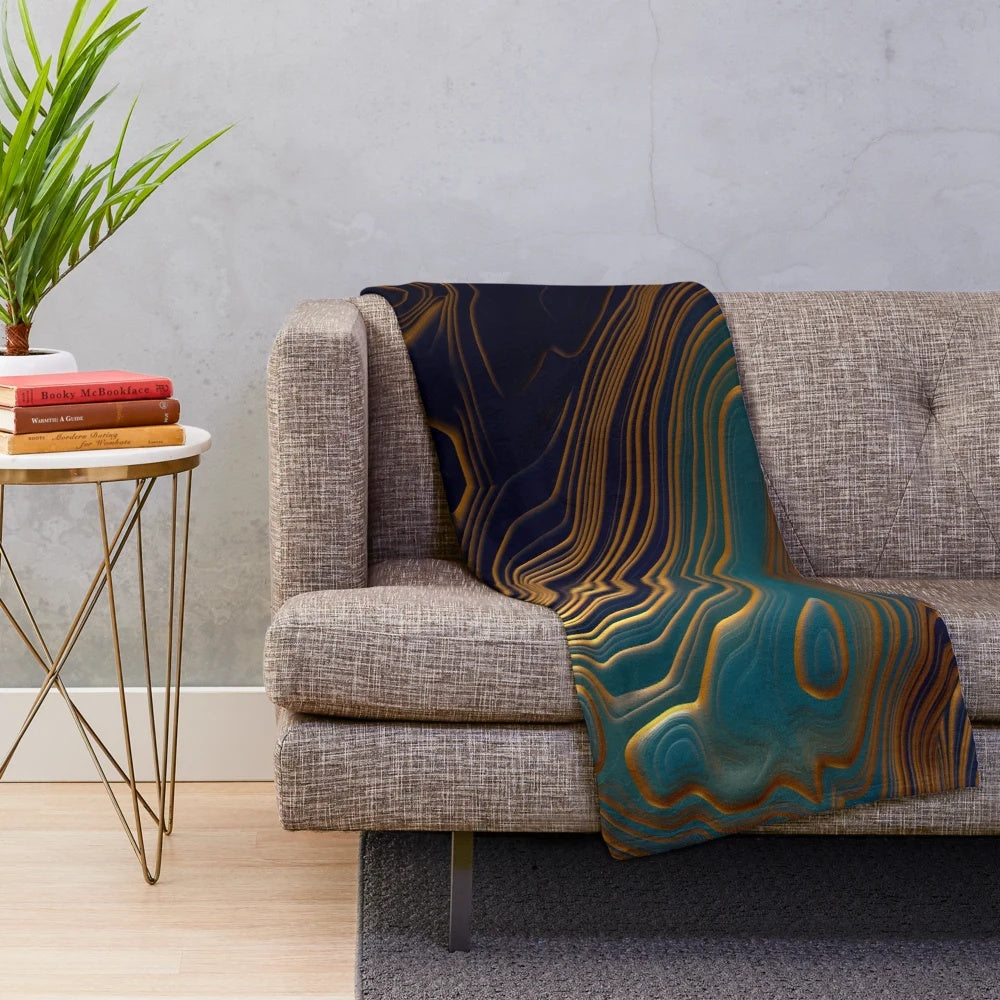 Peacock-inspired plush blanket with abstract ocean-like patterns and metallic accents