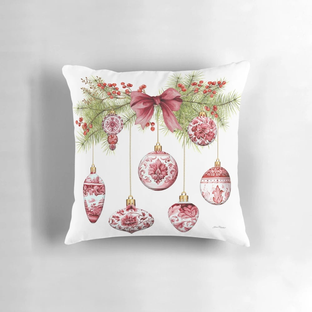 A red and gold chinoiserie-style Christmas ornament pillow with pine branches and berries
