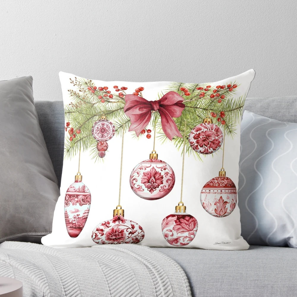 A red and gold chinoiserie-style Christmas ornament pillow with pine branches and berries
