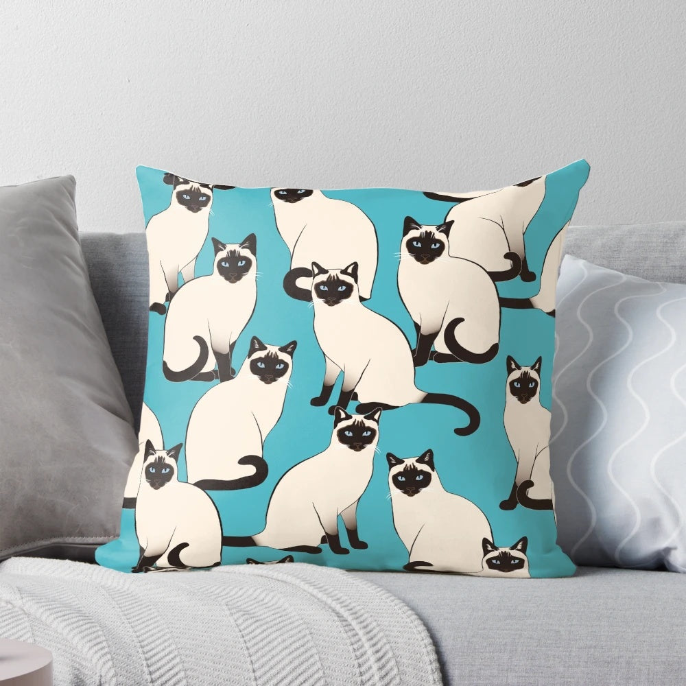 Decorative pillow featuring an elegant pattern of Siamese cats with blue eyes on a turquoise background