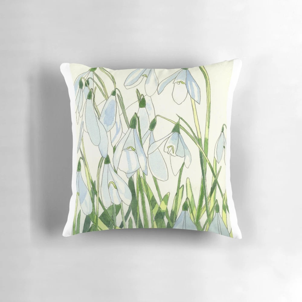 Soft, white snowdrops watercolor painting on a decorative throw pillow