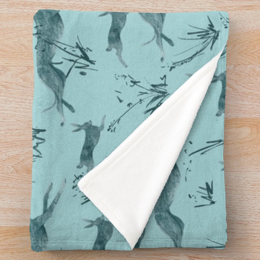 Turquoise plush blanket featuring a greyhound and hare