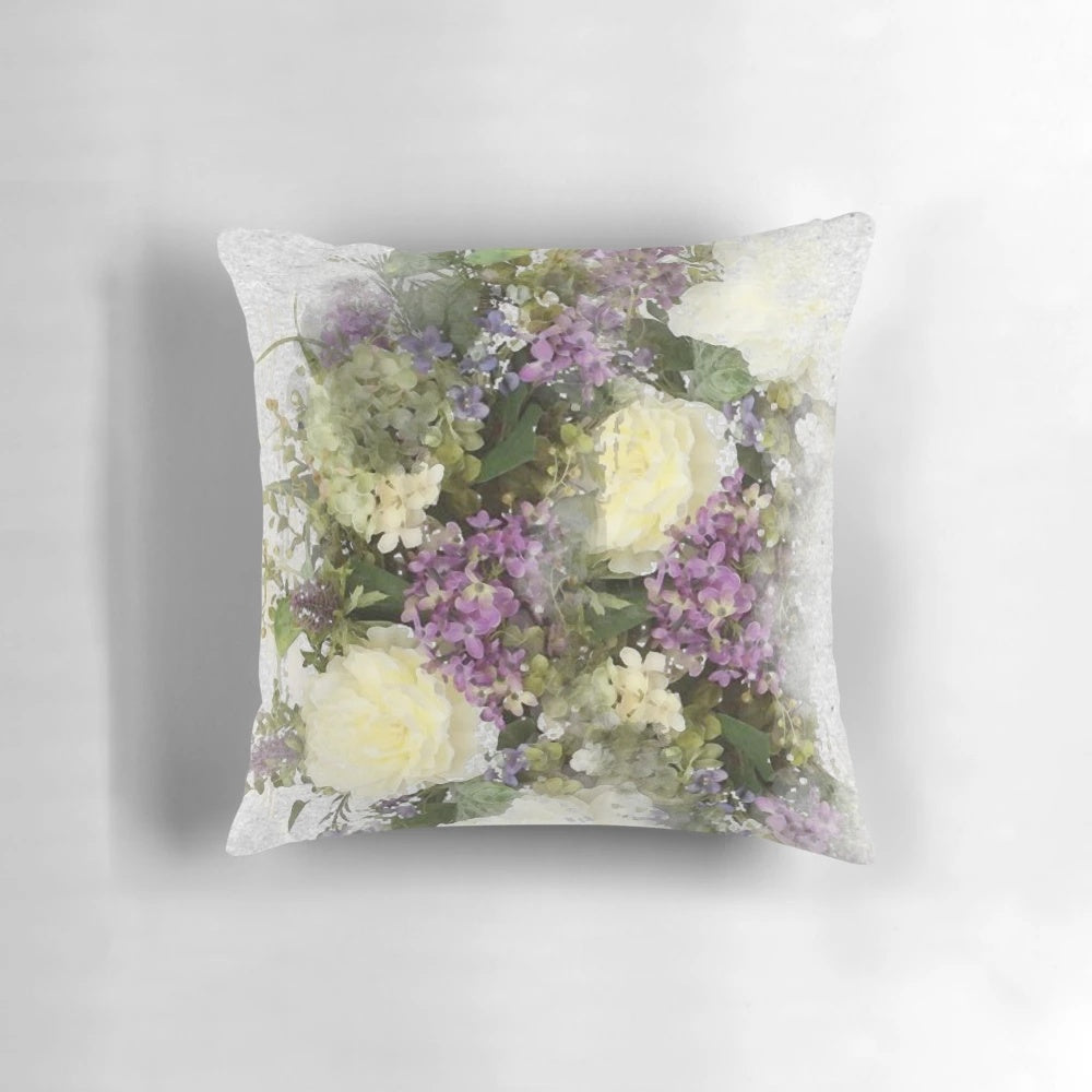 A watercolor painting of a bouquet featuring cream roses and purple flowers on a throw pillow