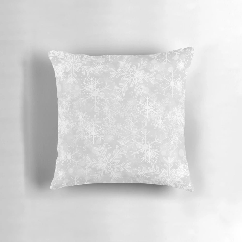 A modern, silver snowflake pattern decorative pillow for winter and holiday home decor.