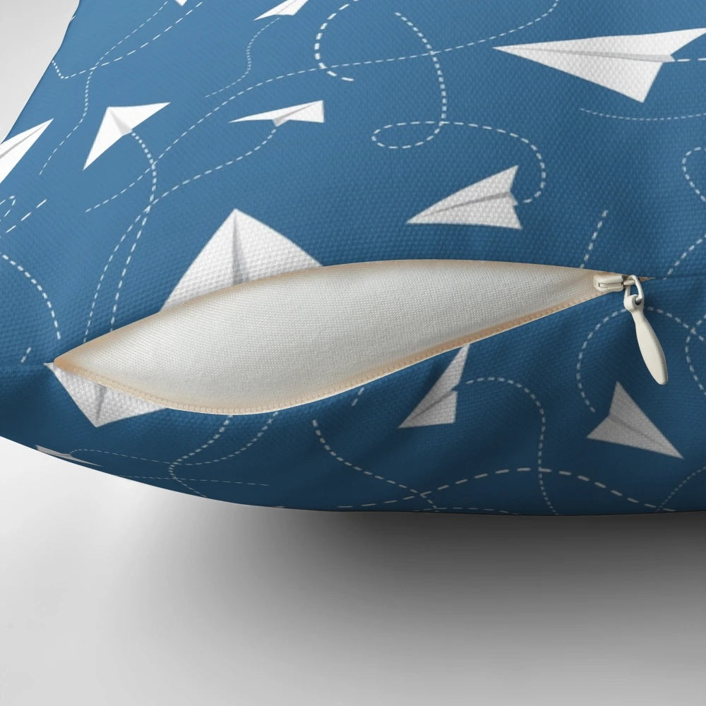 A soft, colorful pillow featuring a paper plane pattern against a blue sky background.