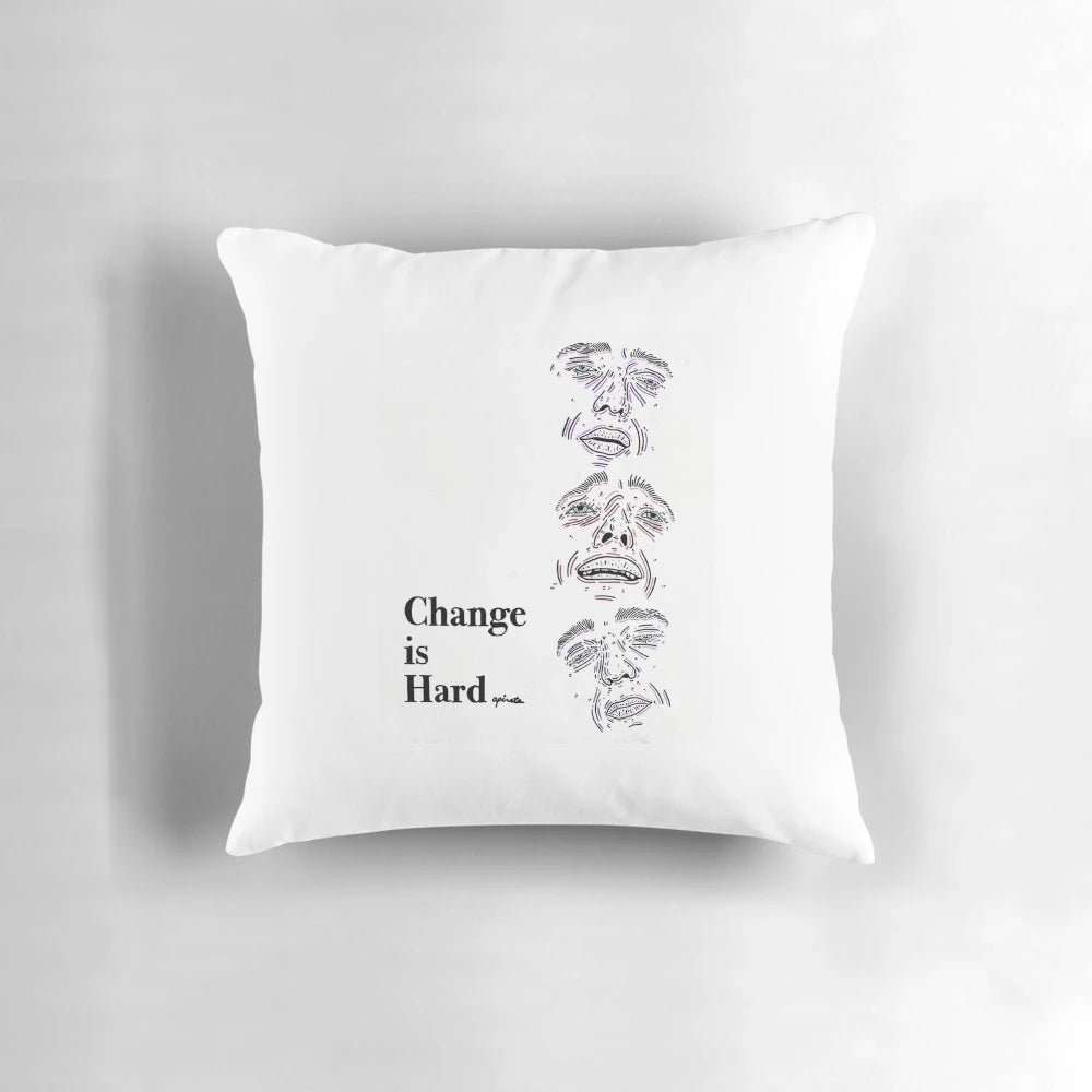 A simple white pillow with the text "Change Is Hard" in a minimalist outline design, inspiring personal reflection and growth.