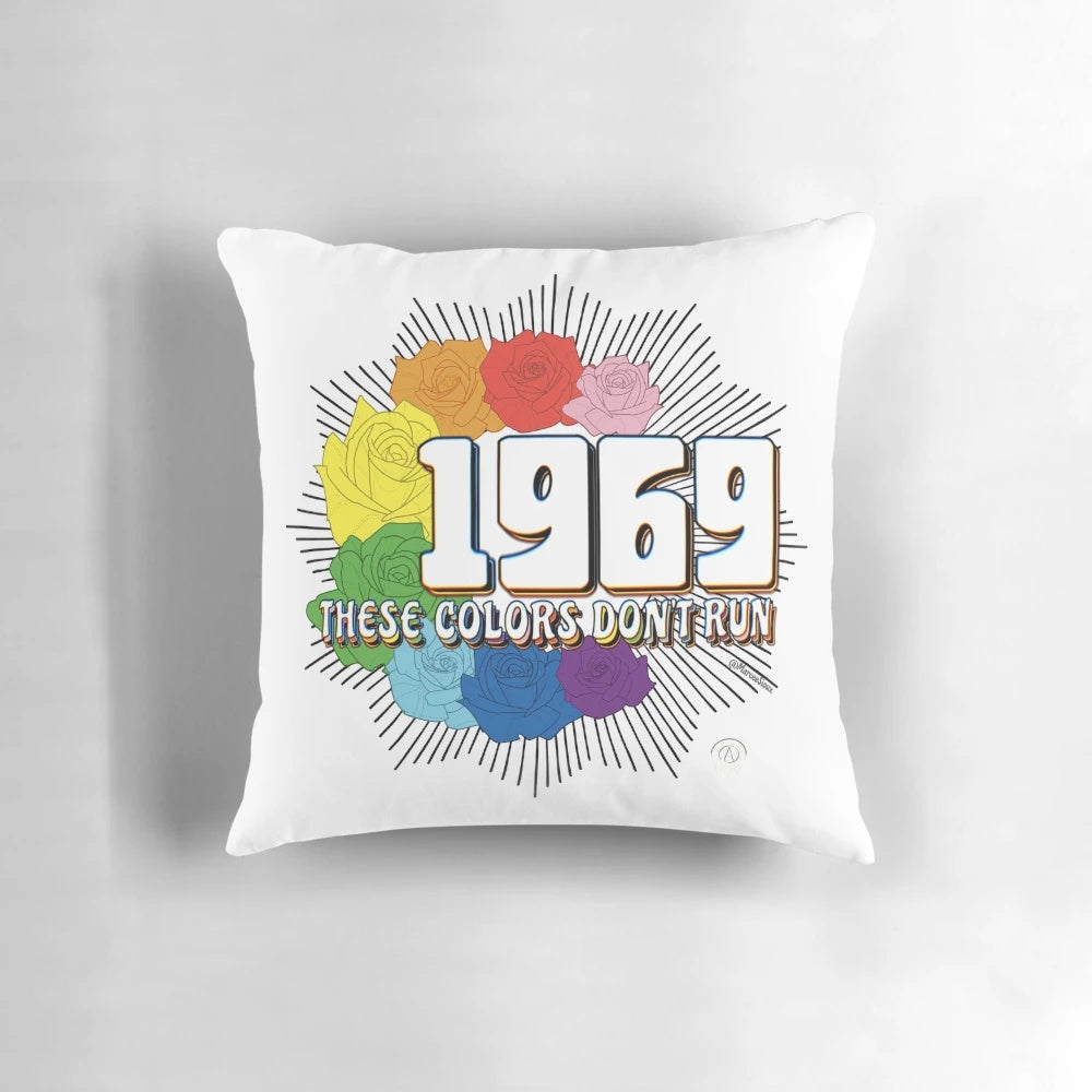 Colorful pillow with text "These Colors Don't Run" against a diverse background, representing inclusivity and social justice.
