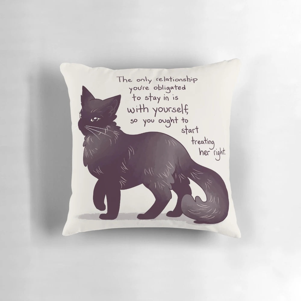 A black cat pillow with an inspiring message about self-love and mental health recovery