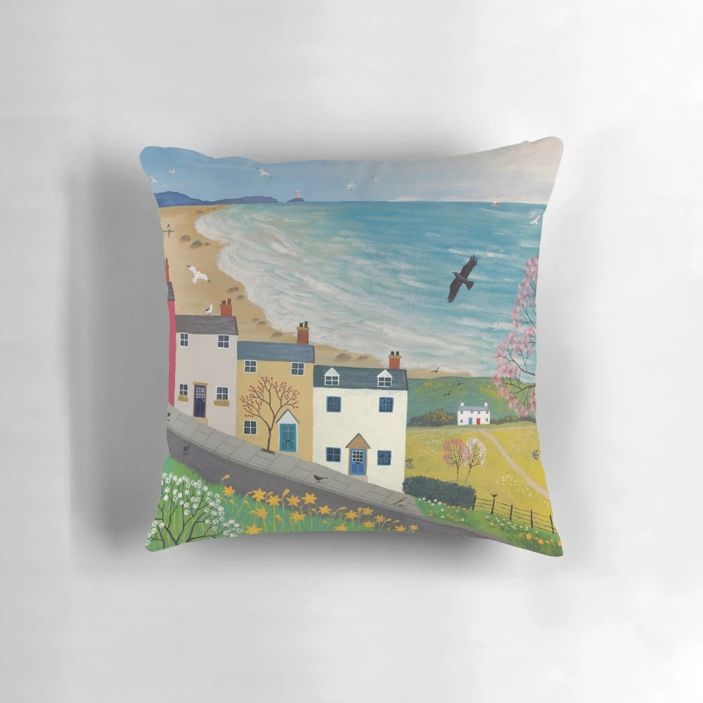 A colorful spring-themed pillow featuring landscapes, wildlife, and nature imagery