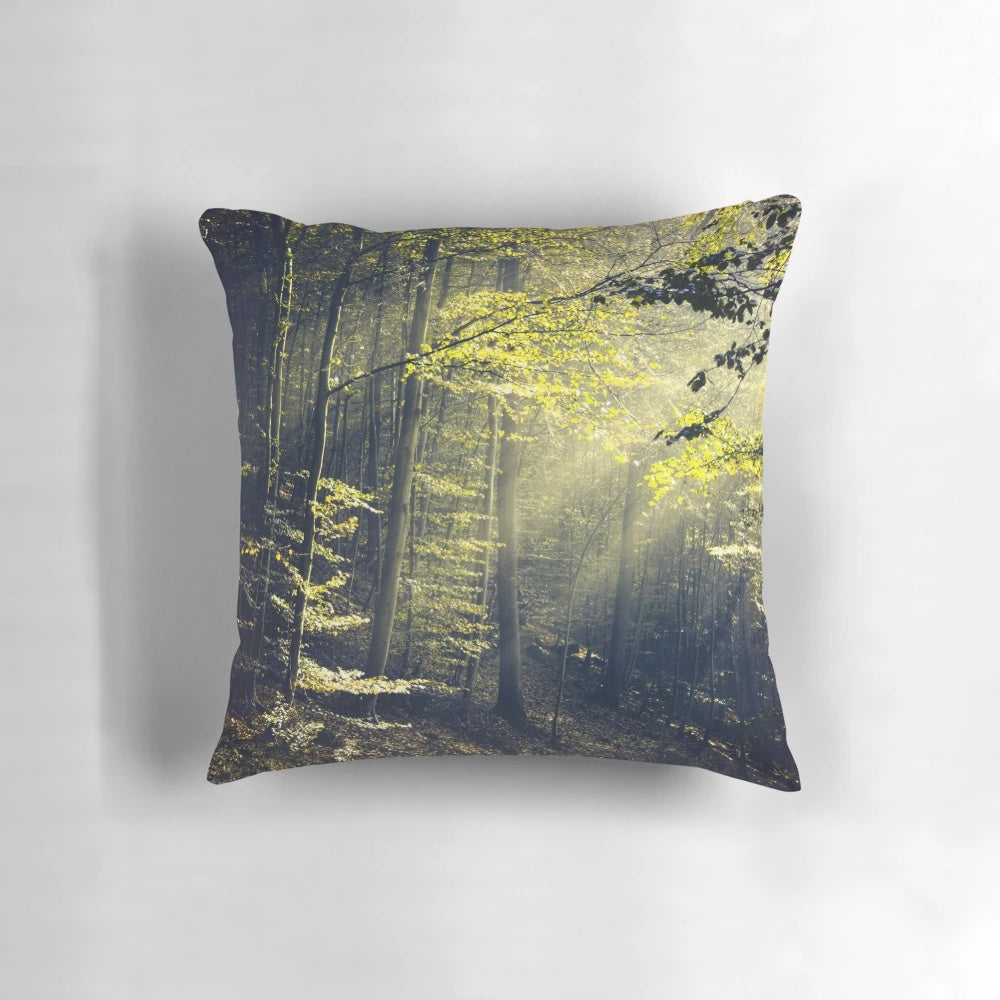 A Pillow featuring a serene forest landscape with rays of morning light filtering through the trees.