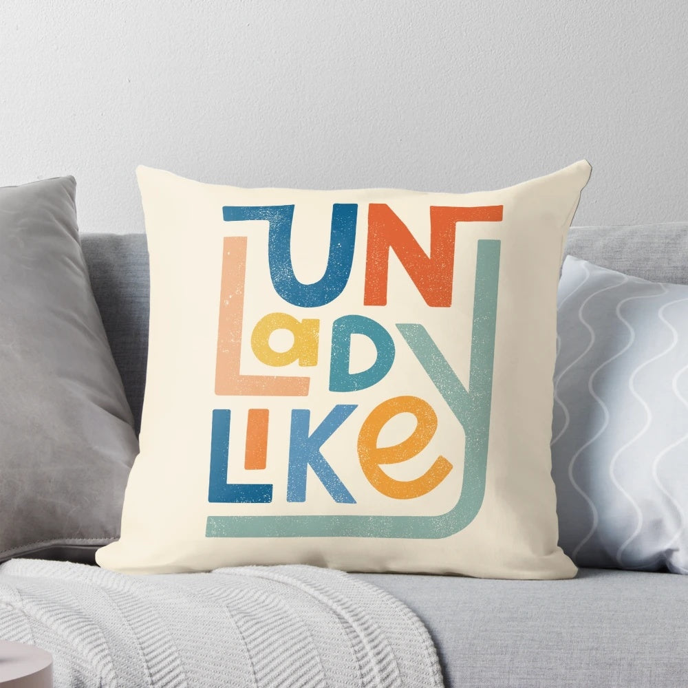 Vibrant UNLADYLIKE graphic design pillow featuring bold lettering and a feminist message.