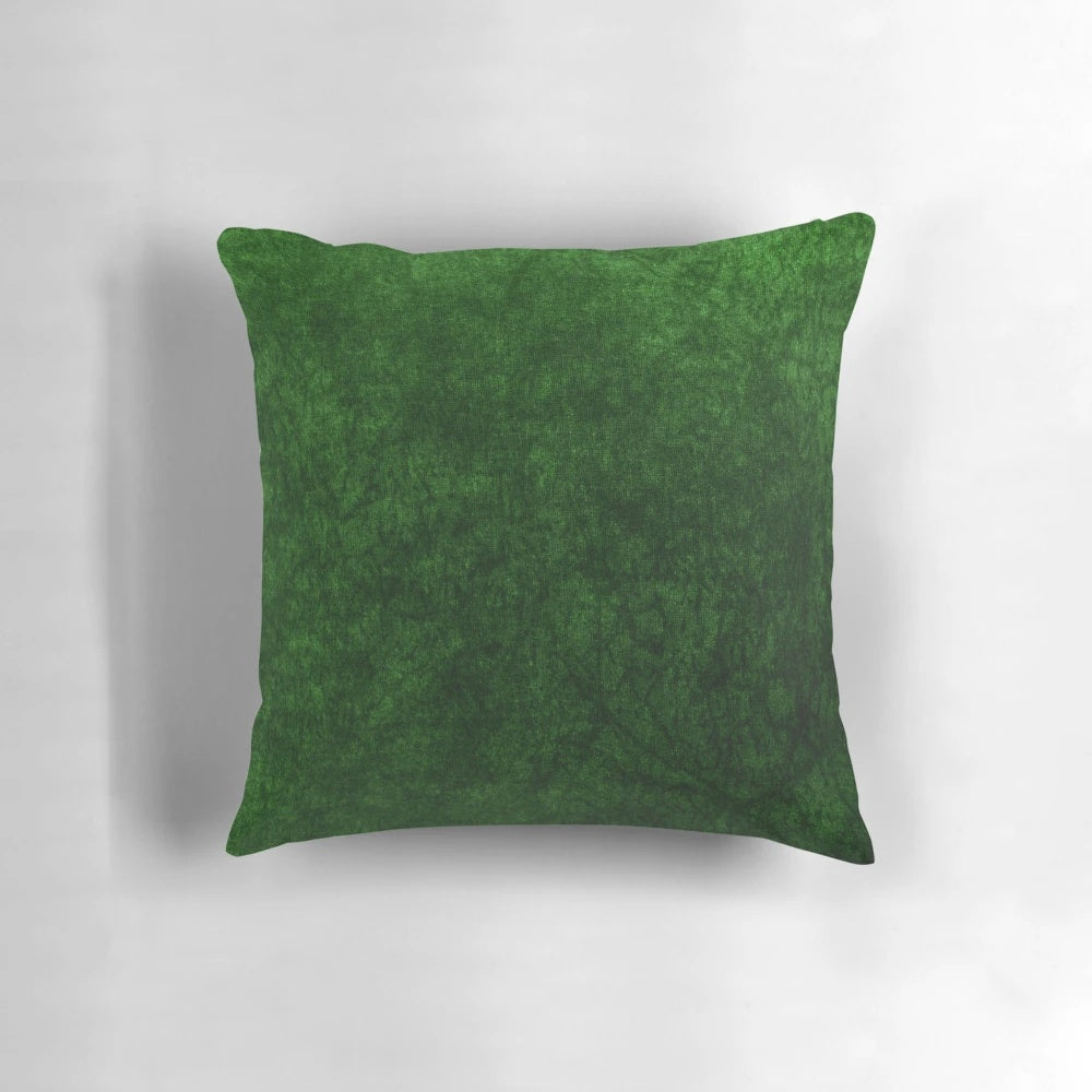 Emerald green velvet accent pillow with a soft, textured surface for modern, minimalist home decor.