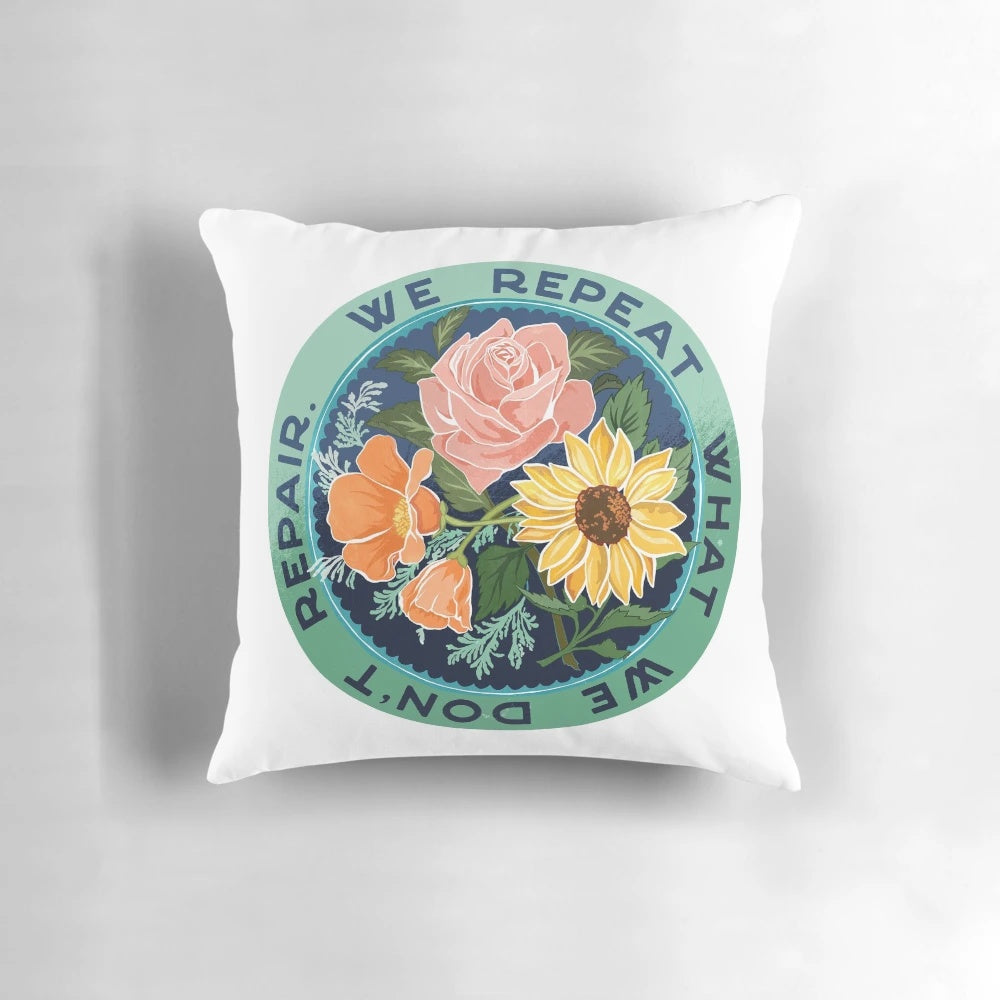 Decorative throw pillow with a floral bouquet design and the text "We Repeat What We Don't Repair