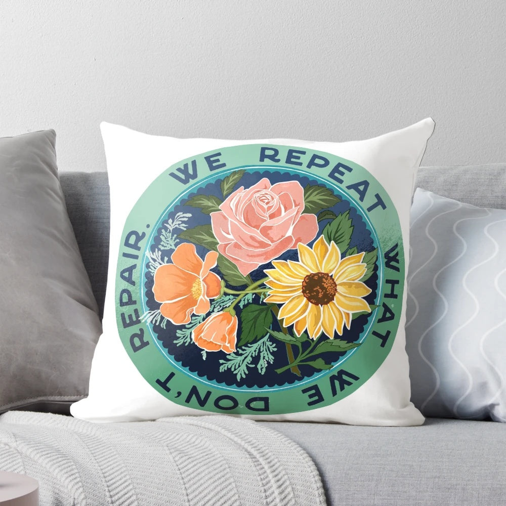 Decorative throw pillow with a floral bouquet design and the text "We Repeat What We Don't Repair