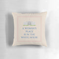 A decorative pillow with the text "A Woman's Place is in the White House"