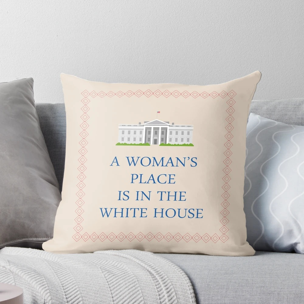 A decorative pillow with the text "A Woman's Place is in the White House"