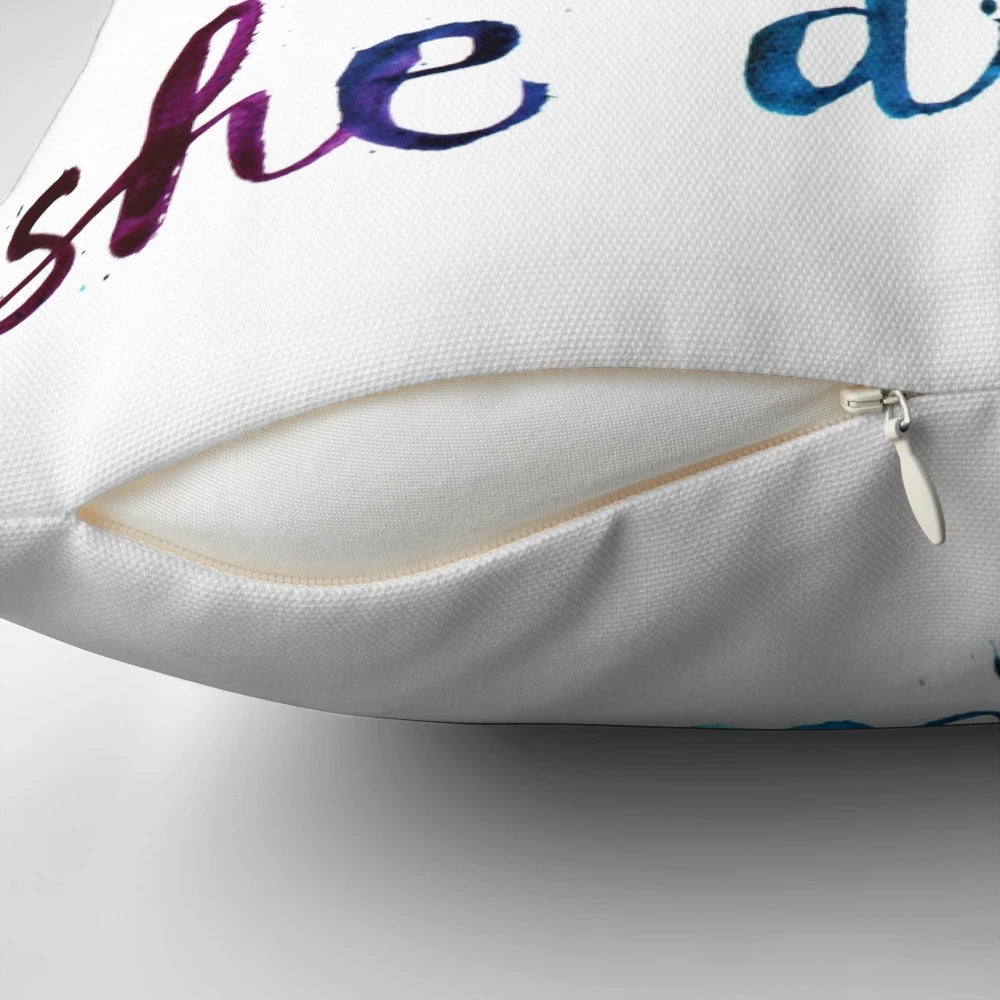 Decorative pillow with the motivational quote "She believed she could so she did" in calligraphic typography and watercolor design.