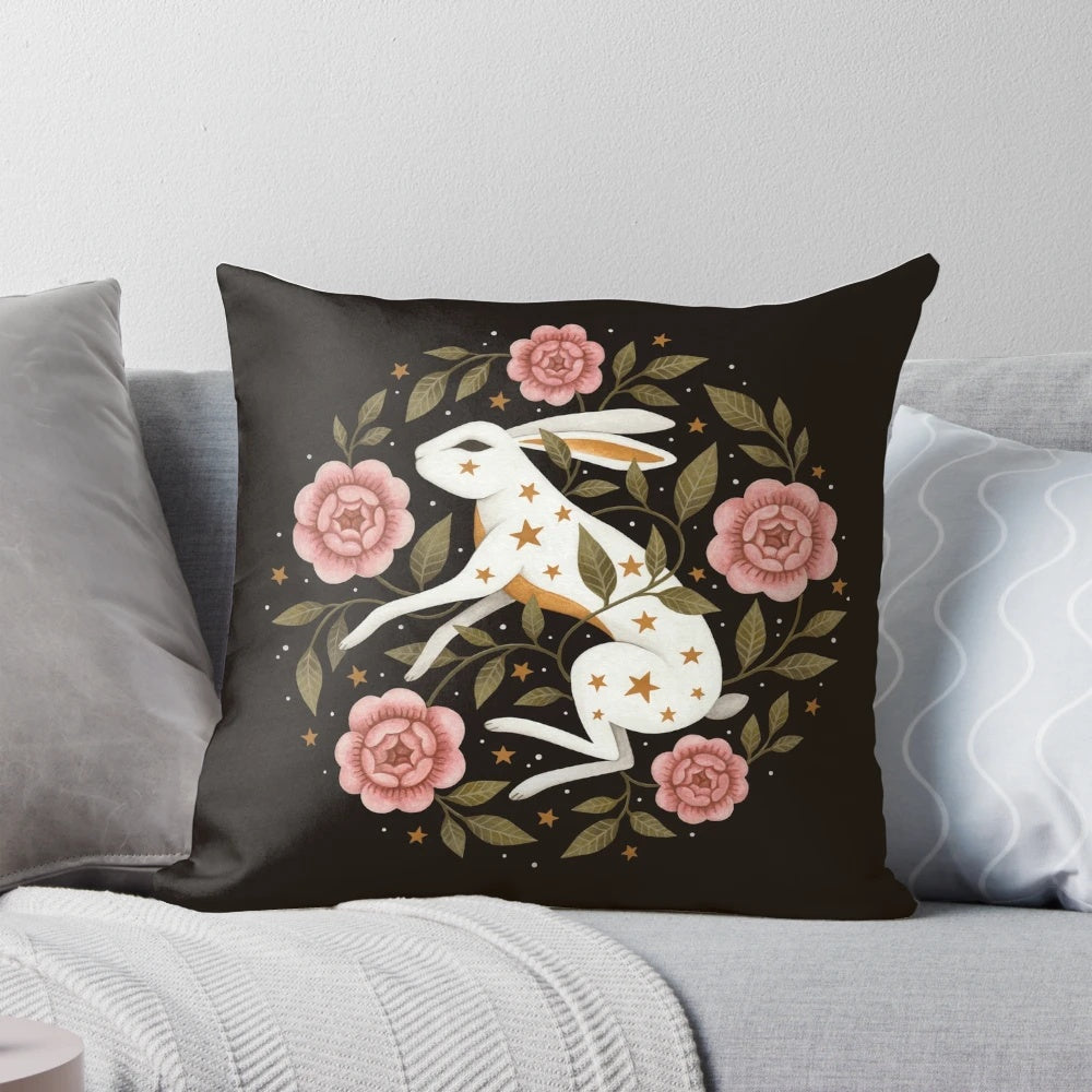 A captivating pillow featuring an intricate, nature-inspired design with rabbits, flowers, and stars.