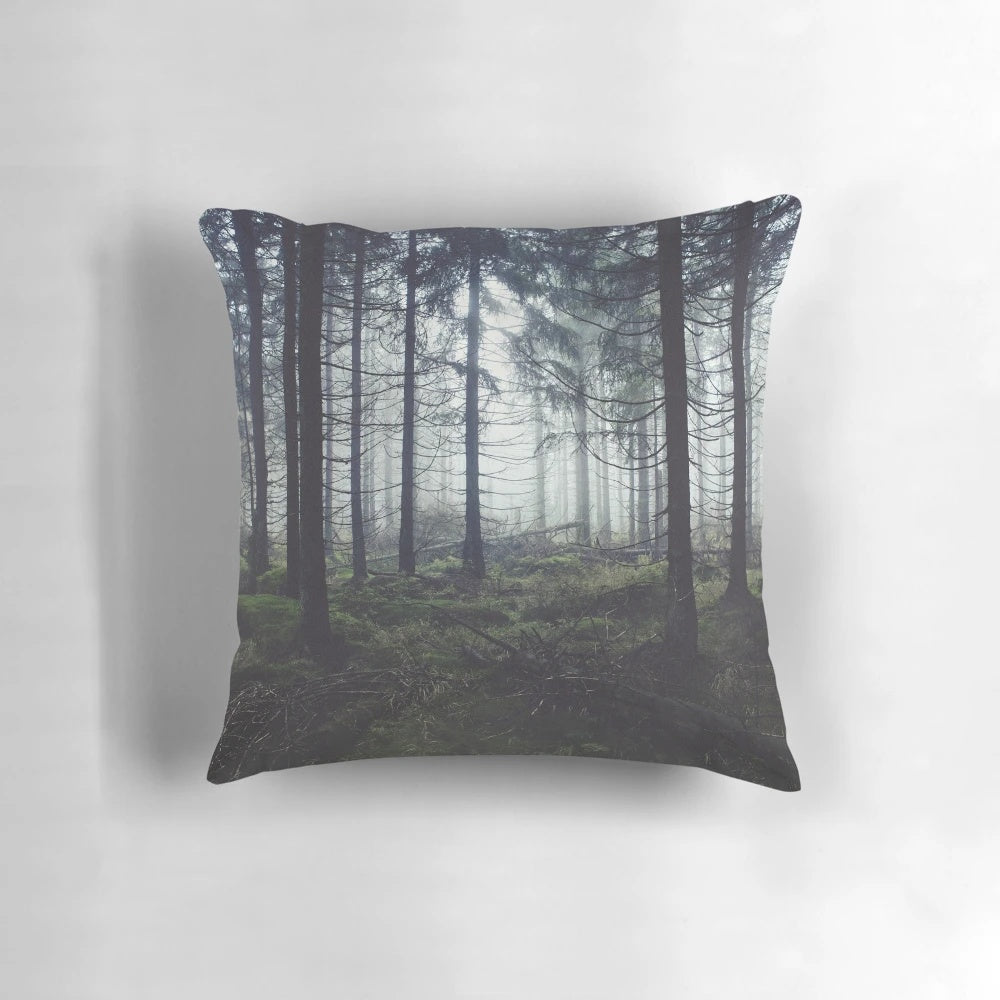 Pillow featuring a dreamy, misty forest scene with trees and fog