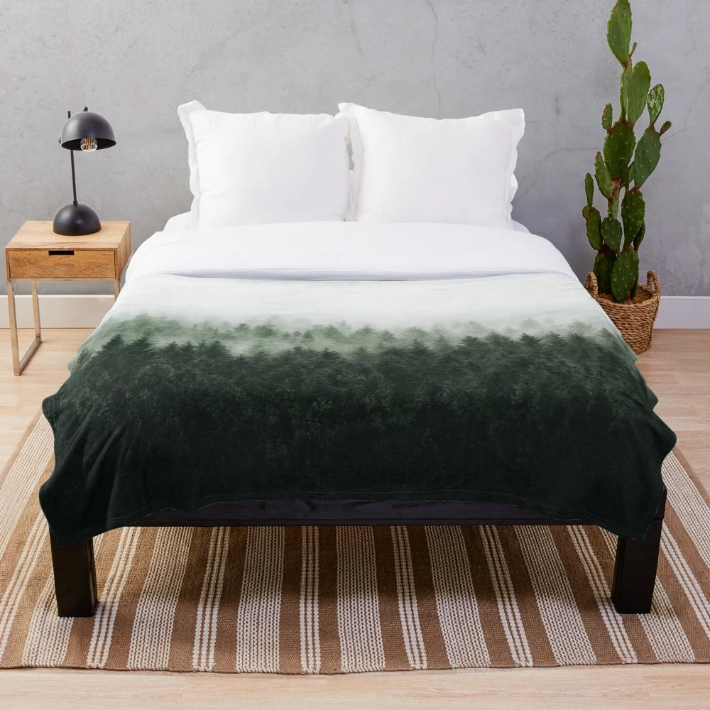 Plush blanket featuring an enchanted forest landscape with misty trees and magical light