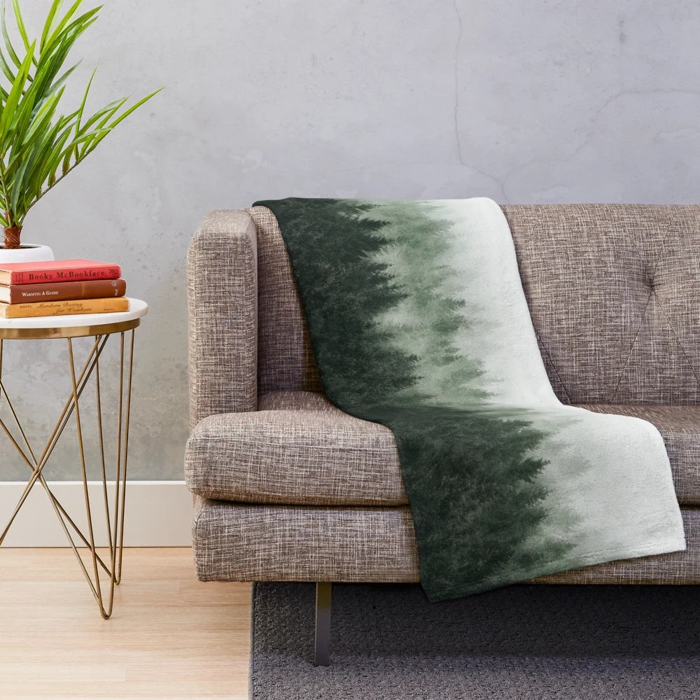 Plush blanket featuring an enchanted forest landscape with misty trees and magical light