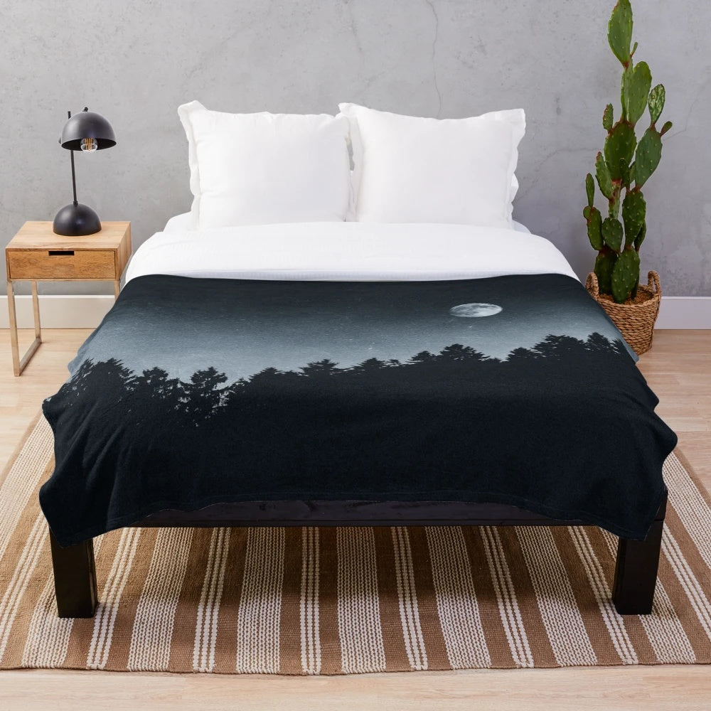 Plush blanket featuring a forest scene with trees, moonlight, and a dark night sky