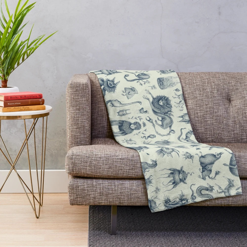 Plush blanket featuring a pattern of fantasy creatures and mythical beings