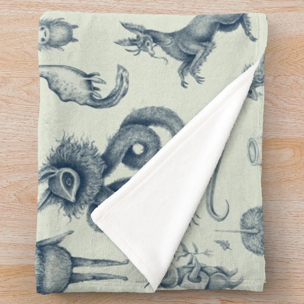 Plush blanket featuring a pattern of fantasy creatures and mythical beings
