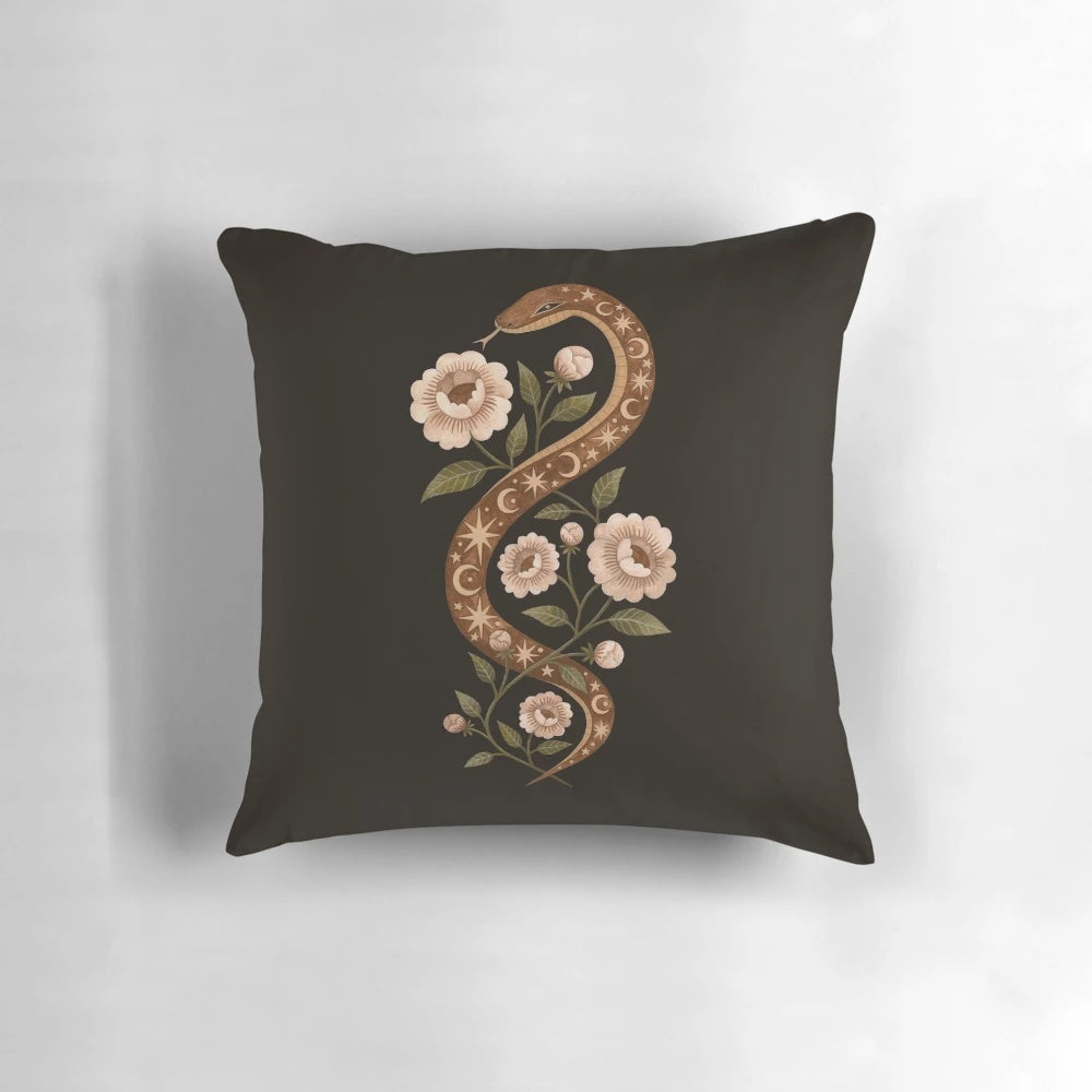 A decorative pillow featuring a serpent or snake design in a mystical, enchanted floral scene with stars and moon.