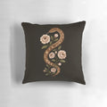A decorative pillow featuring a serpent or snake design in a mystical, enchanted floral scene with stars and moon.