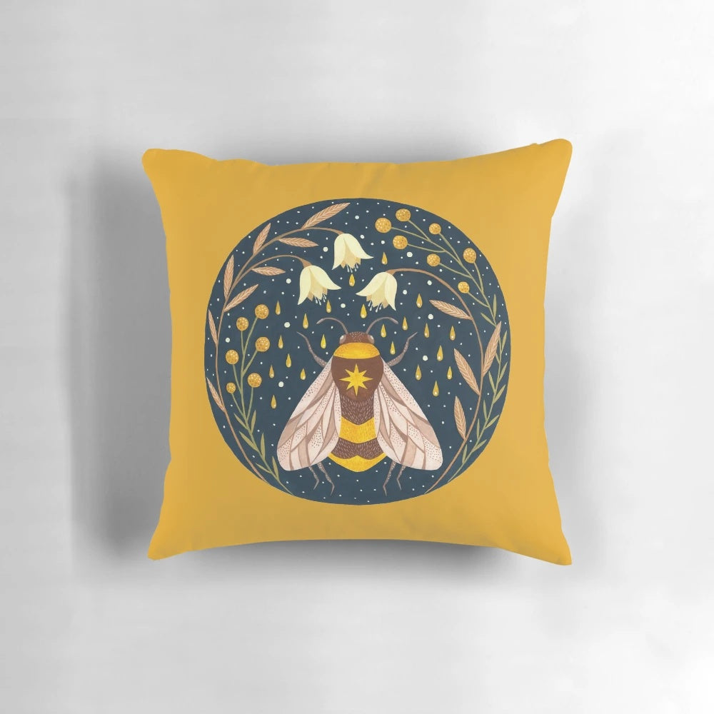 Decorative pillow featuring a golden floral design with buzzing bees
