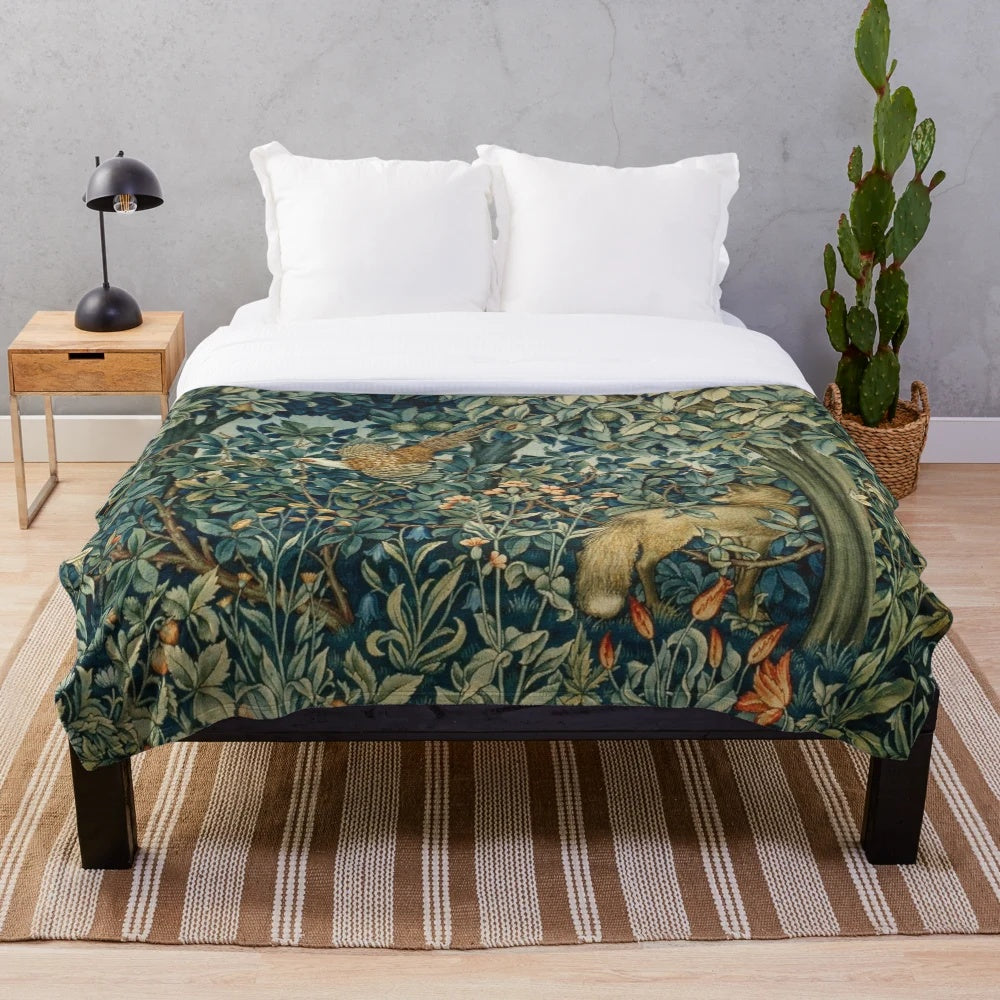 Plush blanket featuring a blue green floral tapestry design with forest animals like pheasant and fox