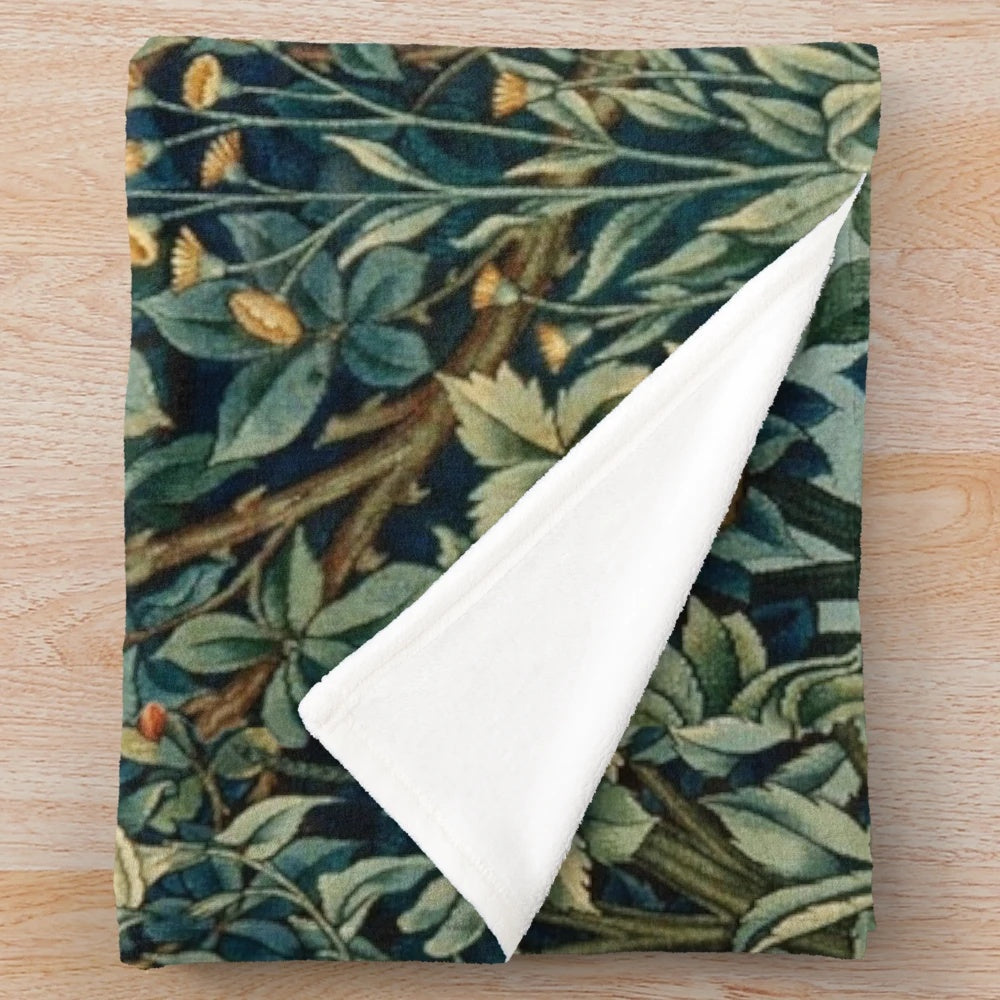 Plush blanket featuring a blue green floral tapestry design with forest animals like pheasant and fox