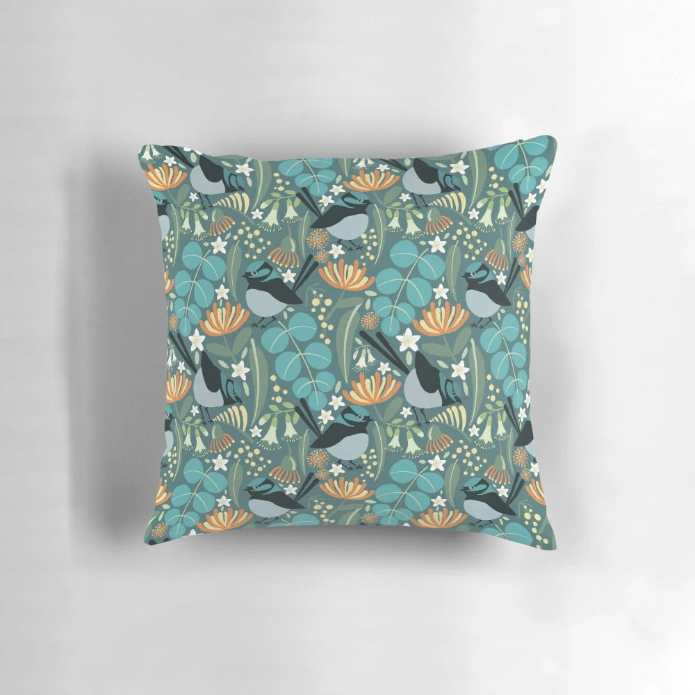 A vibrant blue wren bird perched on a blue gum tree branch, featured on a plush decorative pillow.