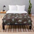 Soft and cozy plush blanket featuring a whimsical design of books and flowers in a fantasy woodland setting