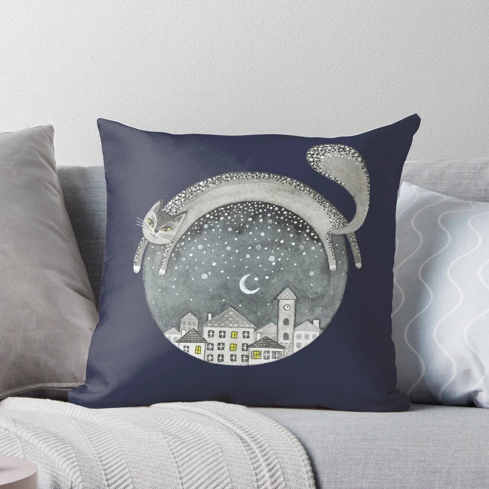 Cozy pillow featuring a whimsical cat in a night town scene with the moon, stars, and houses.