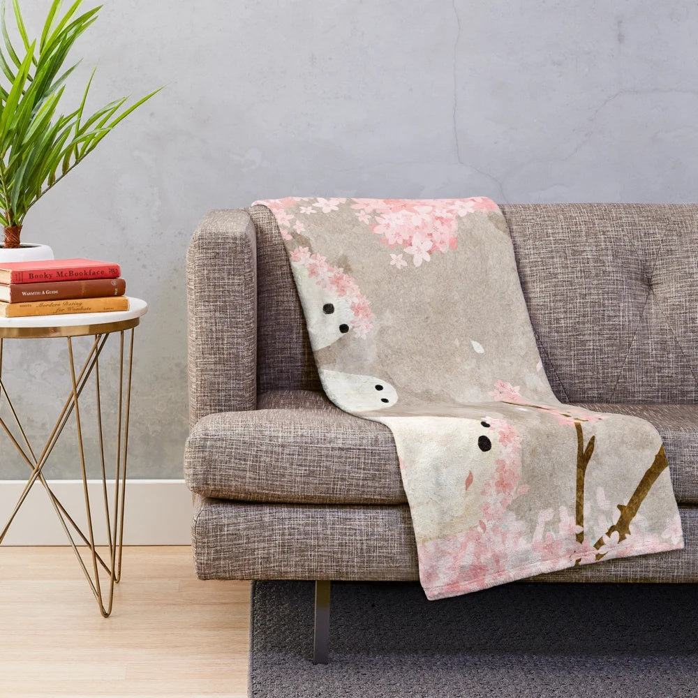 Soft and cozy cherry blossom plush blanket with delicate pink floral design