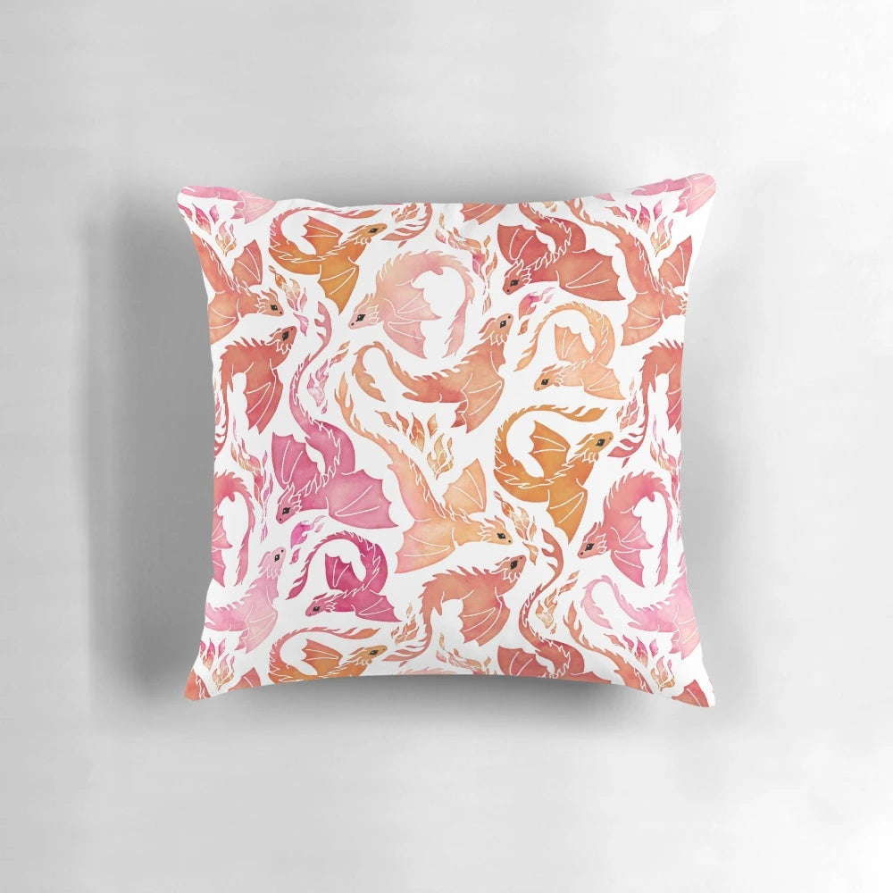 Whimsical watercolor-style dragon pillow with fiery pink and orange colors, perfect for adding a touch of magic to your home decor.