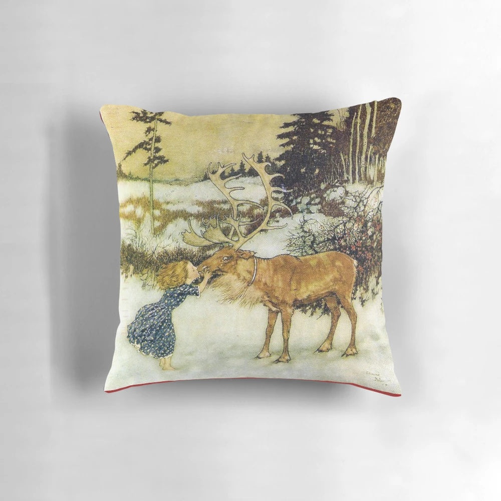 Decorative pillow featuring the iconic illustration "Gerda and the Reindeer" by Edmund Dulac, depicting a girl kissing a reindeer in a snowy winter landscape.