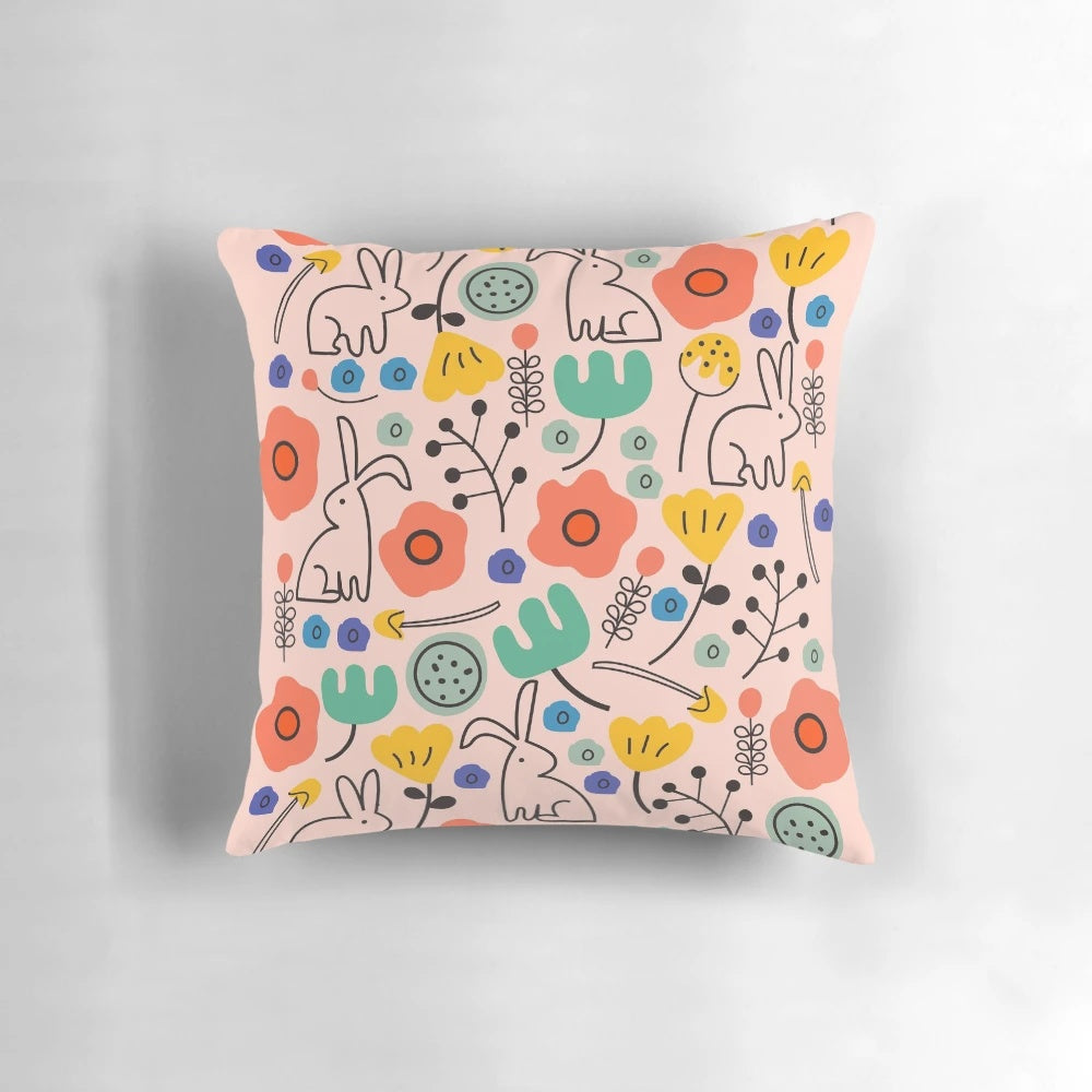 Soft, pink floral pillow with bunnies and leaves, perfect for garden-inspired home decor