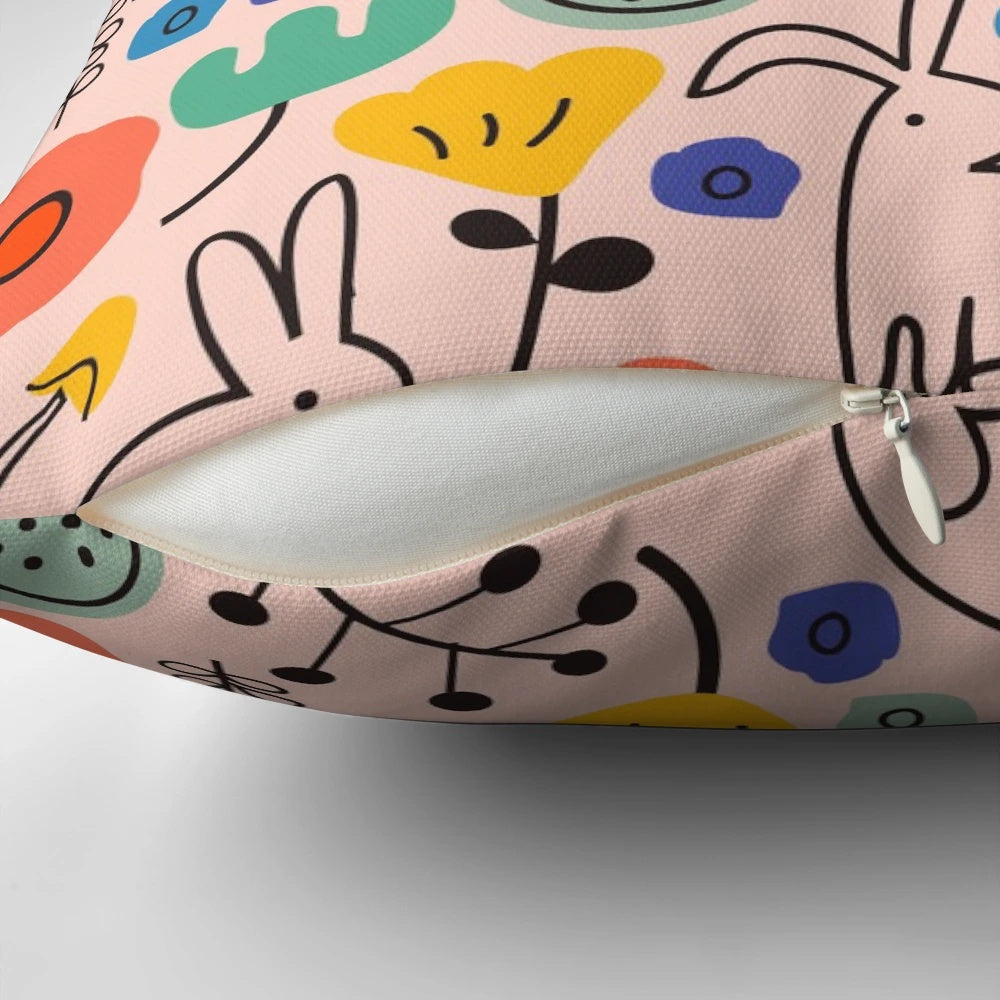 Soft, pink floral pillow with bunnies and leaves, perfect for garden-inspired home decor