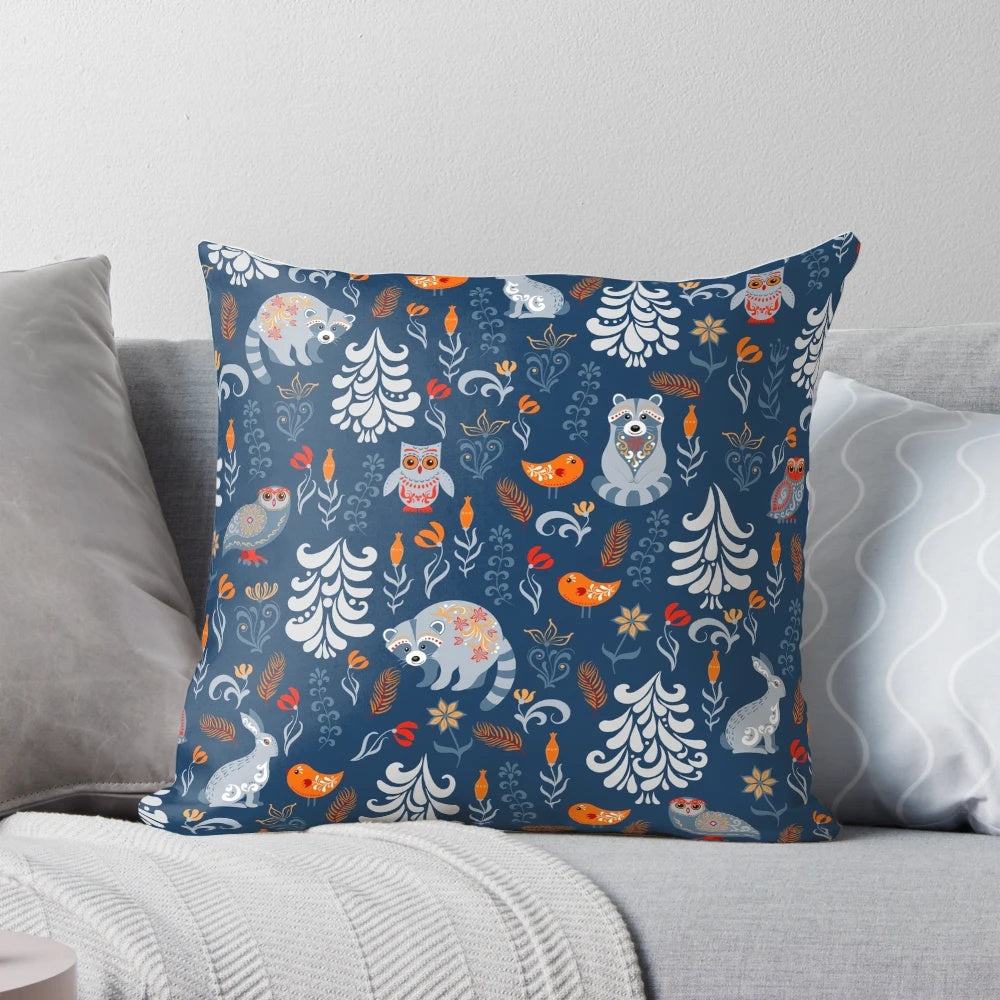 Decorative pillow featuring a whimsical pattern of forest animals like raccoons, owls, bunnies, and a chick in an autumnal woodland setting.